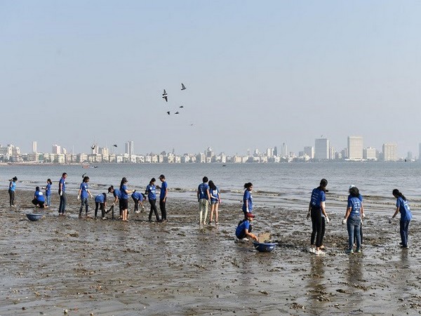 Volunteers wearing t-shirts made from recycled plastic collecting garbage at Girgaum Chowpatty during the mega clean-up drive held to celebrate Global Recycling Day