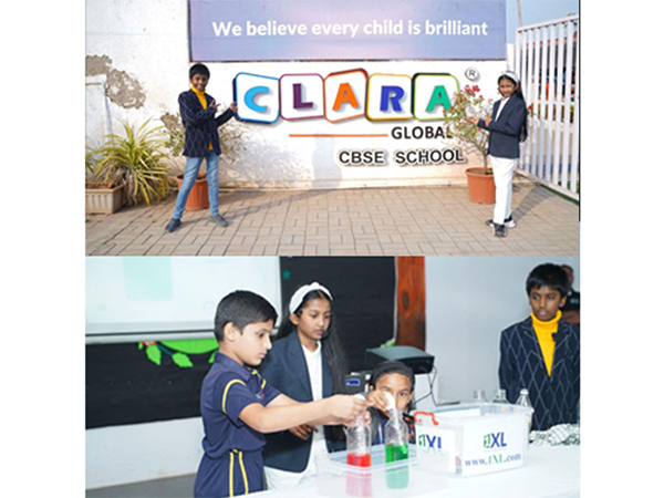 Jainam and Jivika Jain, co-founders of 1XL, pointing at the entrance gate of Clara Global School, showcasing their partnership for the 'Magical Science' workshop.