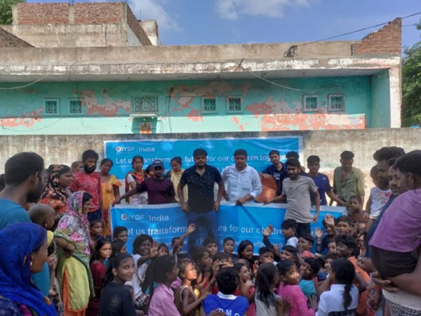 Community and volunteers with children at Usman Pur Basti during Lokpriya Pustak Sansaar aid event