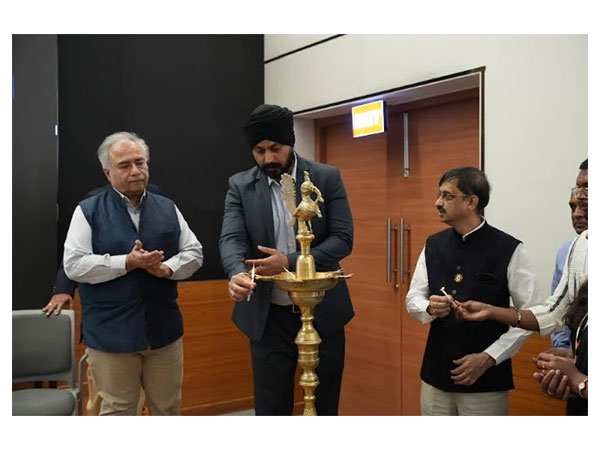 Dignitaries lighting the lamp at the B.Com. launch event