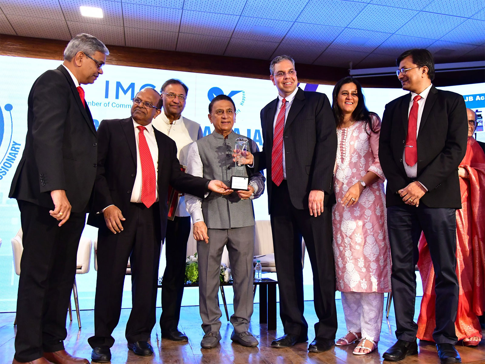 Sameer Kanodia, MD & CEO of Lumina Datamatics, with the leadership team, receives the IMC RBNQA Performance Excellence Trophy 2025 at IMC, Mumbai, from cricket legend Sunil Gavaskar