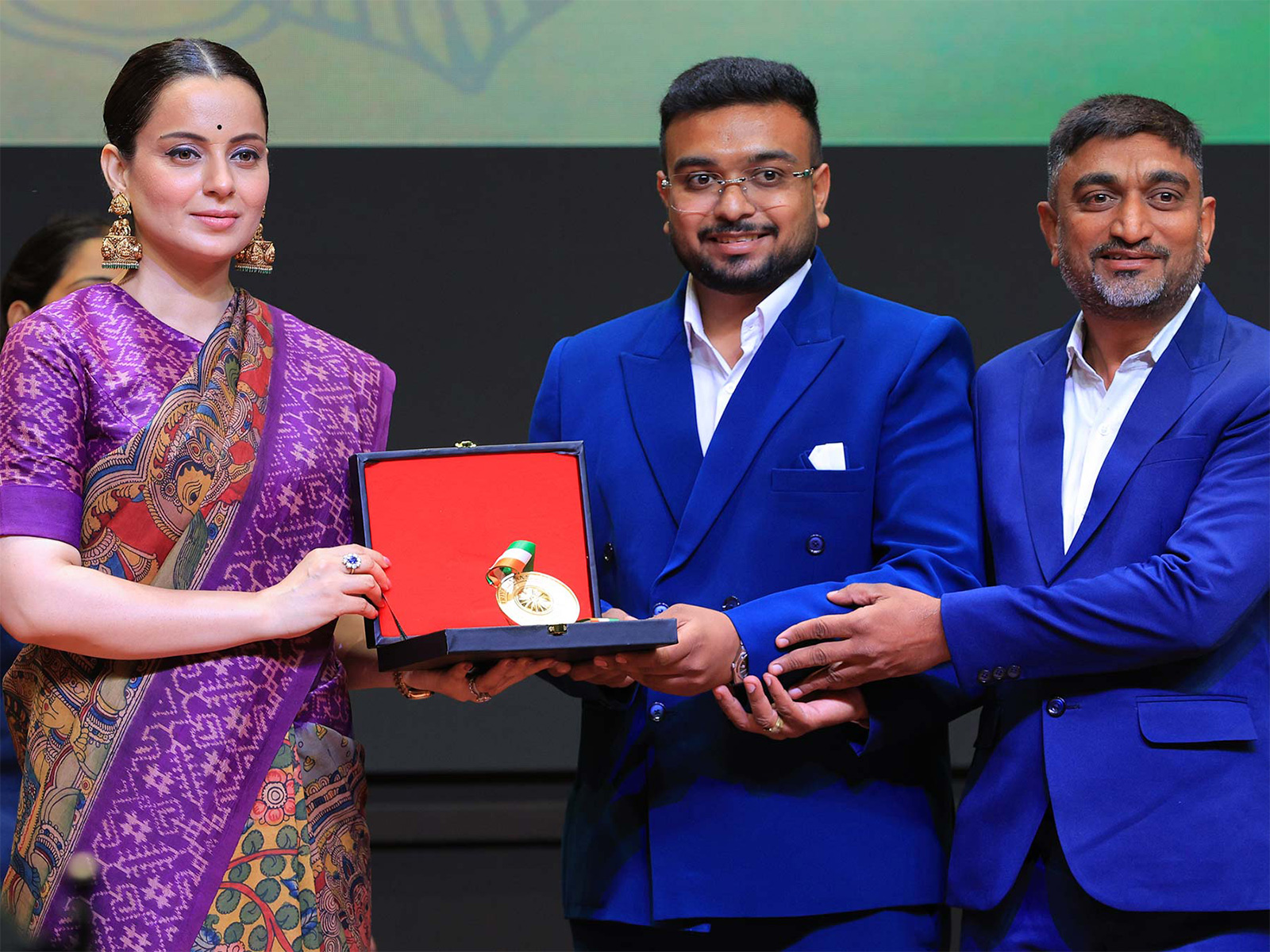 On stage at the Rashtriya Ratna Samman 2026, Mr. Hensibhai Dhaduk, Managing Director, and Mr. Dilipbhai Dhaduk, Director of Balaji Fire Safety, receive the award for 'Best Fire Safety Equipment Manufacturers In West India' from Ms. Kangana Ranaut